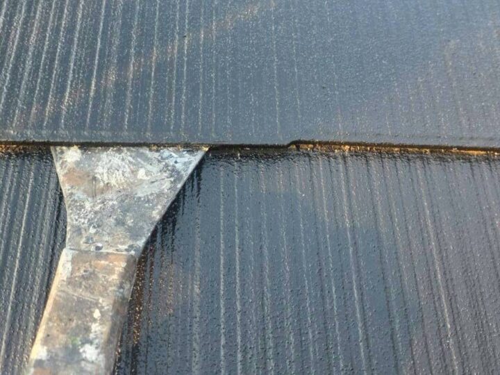 屋根塗装でカッターを使った縁切り作業の様子、スレート屋根重なり部分