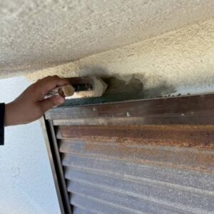 愛媛県の戸建て住宅で外壁塗装前の下地処理を行う施工風景