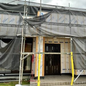 外壁カバー工法のための足場設置作業。安全対策を行い住宅全体を囲う様子