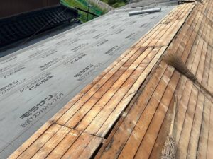 屋根葺き替え工事の下地補修と防水シート施工の様子