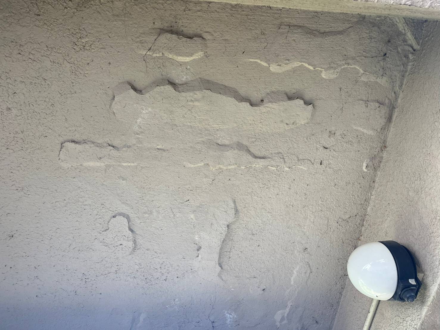 外壁コンクリートの爆裂現象と鉄筋露出の写真