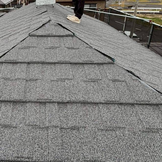 愛媛県の屋根カバー工事における棟板金固定作業の様子