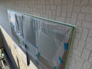 外壁塗装工事中の養生シートで覆われた住宅外観