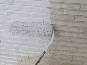 外壁に塗料を塗布している塗装工事の様子